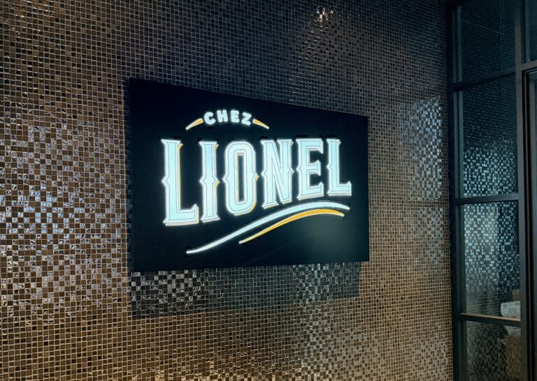 Oliver's Bistro (EN-US) 15 Chez Lionel neon sign on mosaic tile wall