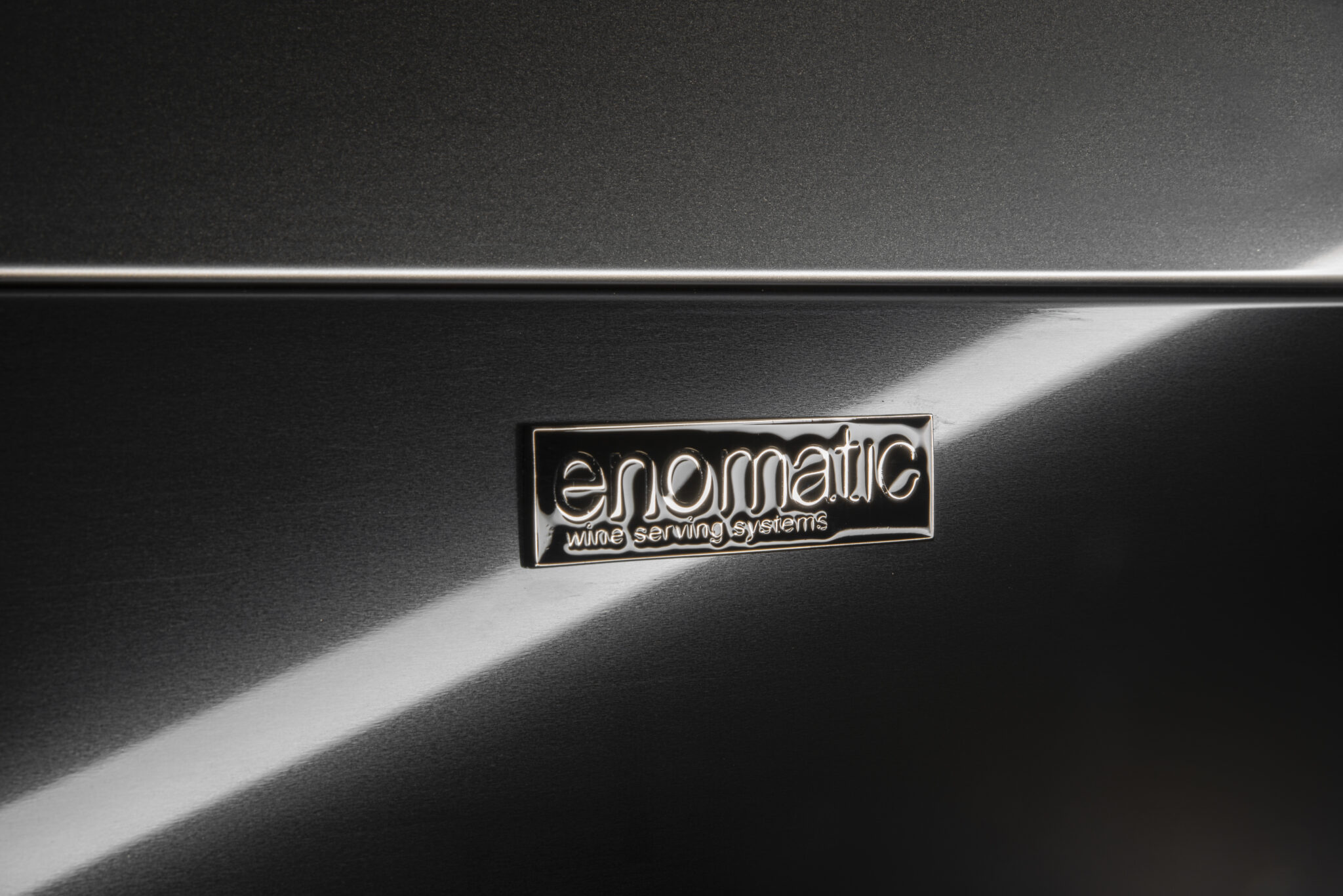 Unica 4 & 8R 6 Macro detail of the Enomatic badge on brushed metal finish